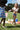 Two young girls playing together outside, one in a DAISY BUG AZUL dress, enjoying a summer picnic.