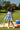 Girl wearing DAISY BUG AZUL - CORISSIA DRESS in a sunny park setting, enjoying a summer picnic.