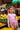 MARACUYA - SUN LONGSLEEVE child in pink swimsuit at fruit market under colorful shade.
