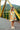 Girl wearing ORQUIDEAS NARANJA - CORISSIA DRESS on a bridge, showcasing the dress's floral design.