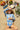 DAISY BUG AZUL - JESS LONGSLEEVE swimsuit on a girl lying on a beach towel with a fruit spread and sunglasses.