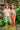 Two children posing outdoors, wearing PLATANAL VERDE - SWIMSHORTS and swimwear, surrounded by tropical plants.